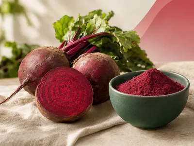 Fresh beetroots next to a bowl of beet root powder